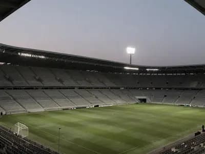 An empty floodlit football stadium in the evening