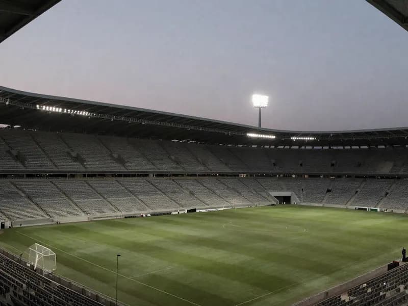 An empty floodlit football stadium in the evening