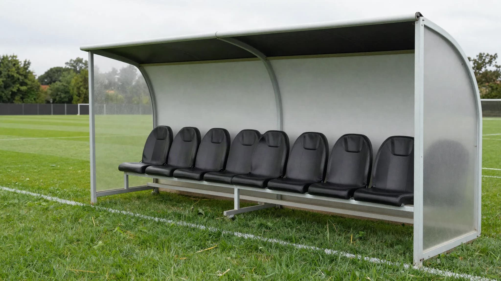 An empty dugout beside a football pitch