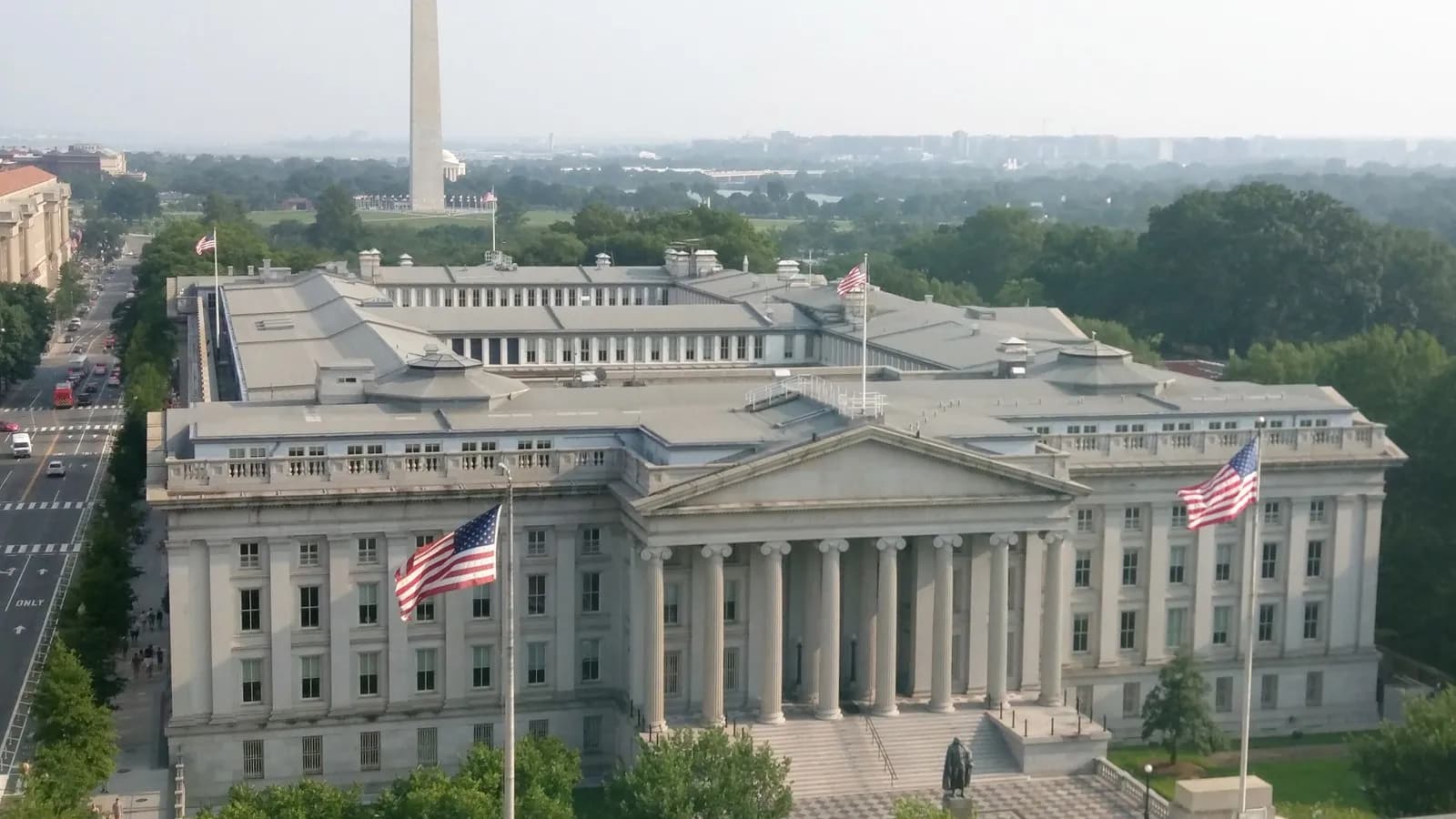 The United States Treasury building in Washington seen from above, with the Washington Monument behind