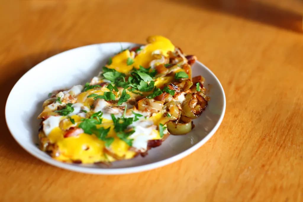 Skillet of Turkish menemen with scrambled eggs, diced tomatoes and peppers, garnished with fresh parsley and red pepper flakes