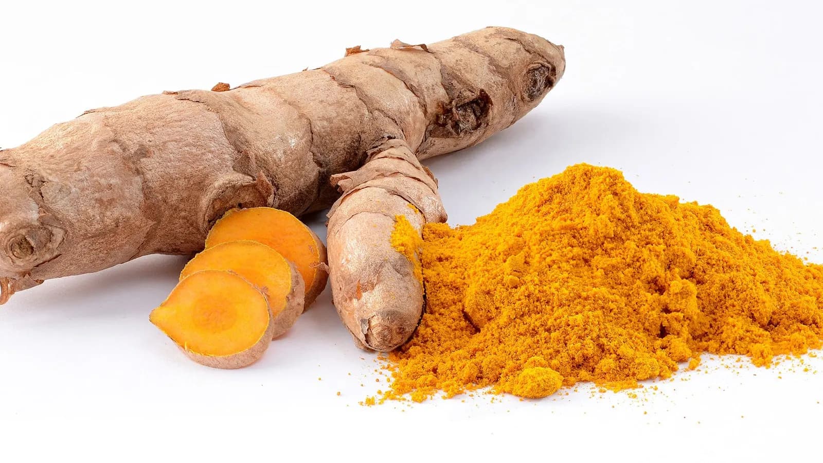 Fresh turmeric rhizome, sliced to show the orange interior, beside a heap of the ground spice. The concern in this piece is with concentrated capsules rather than with the spice itself