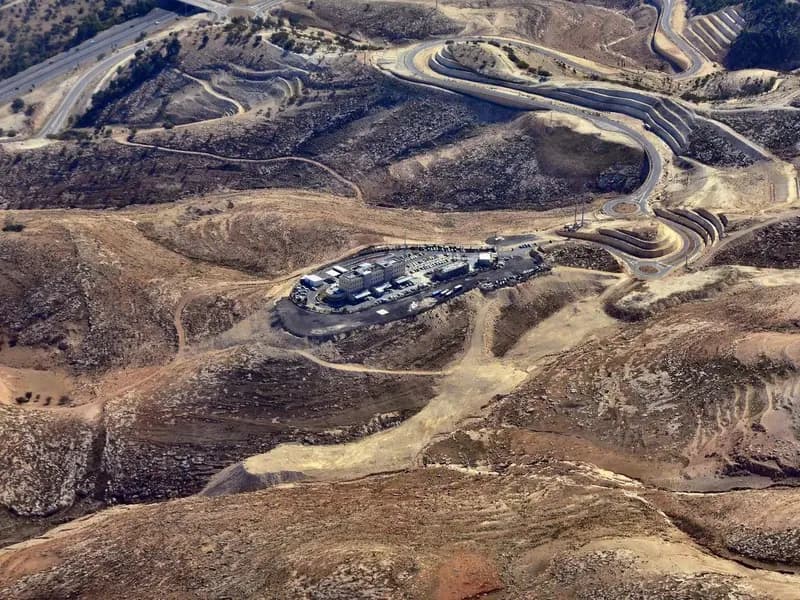 The E1 area east of Jerusalem seen from the air, with the Ma'ale Adumim interchange and the police headquarters built on the site, and bare hills around them