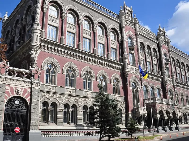 The red-brick facade of the National Bank of Ukraine building on Instytutska Street in Kyiv with Ukrainian flags and the entrance gate, photographed on 6 April 2008, a file photograph of the building and not of this week's searches