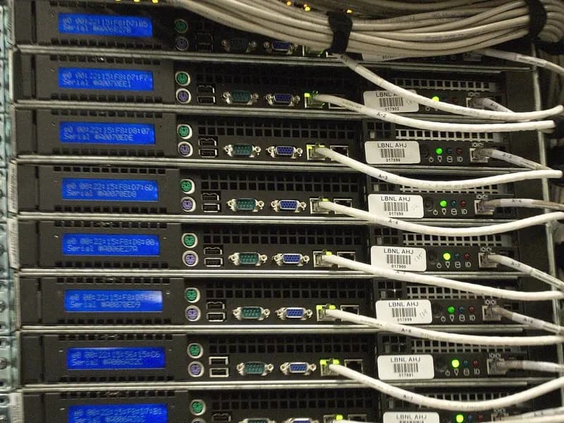 A close view of a data centre server rack with rows of blue LED screens and white Ethernet cables, photographed on 14 October 2011 at a research computing centre in Berkeley, California, a file photograph illustrative of computing hardware and not of any company's AI spending