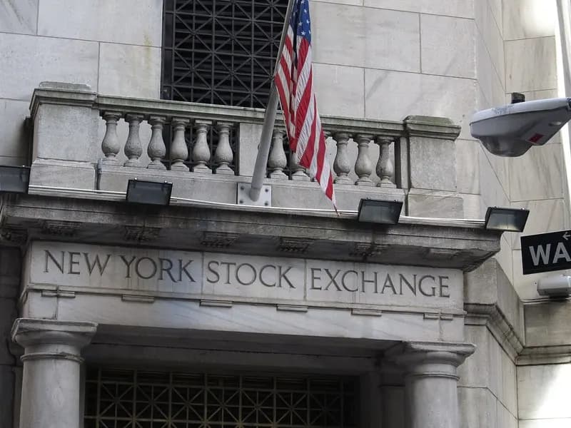 The entrance of the New York Stock Exchange on Wall Street with an American flag and street signs, photographed on 17 May 2012, a file photograph and not from Monday's trading