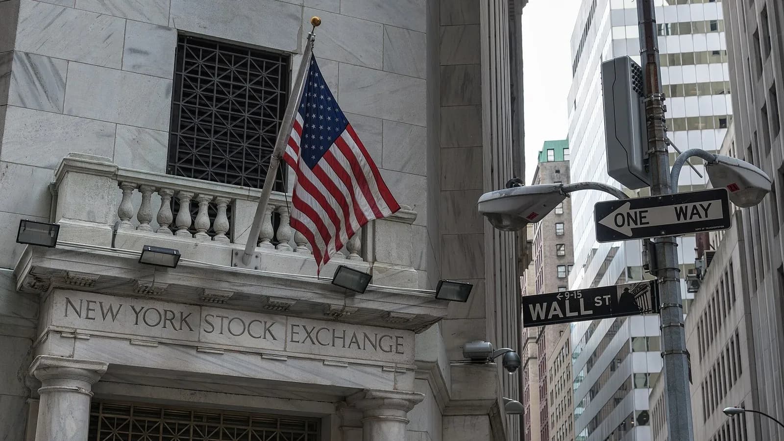 The balcony and carved lettering of the New York Stock Exchange at 11 Wall Street with an American flag, a No Entry sign for Wall Street at right and office towers behind, photographed on 19 August 2015, a file photograph of the exchange building and not of Thursday's trading