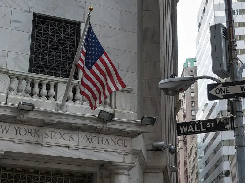The balcony and carved lettering of the New York Stock Exchange at 11 Wall Street with an American flag, a No Entry sign for Wall Street at right and office towers behind, photographed on 19 August 2015, a file photograph of the exchange building and not of Thursday's trading
