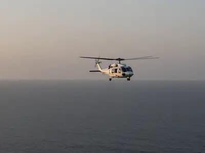 A rescue helicopter over open sea at dawn