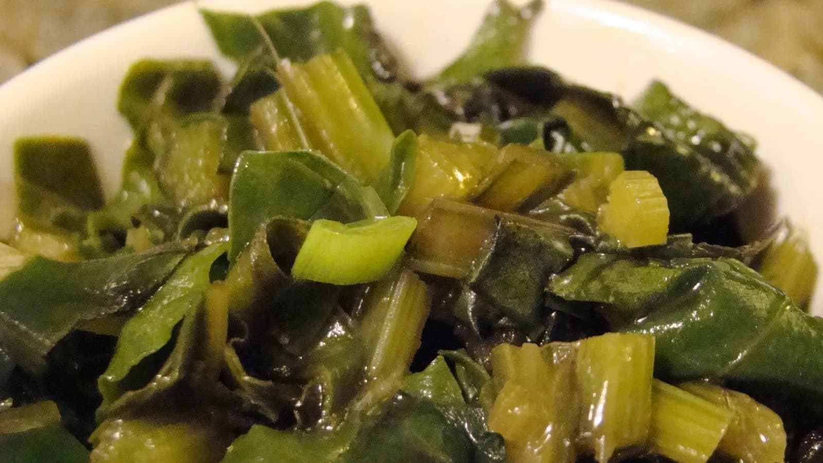 A bowl of cooked beetroot greens and their pale chopped stems, the two thirds of the bunch that most people throw away