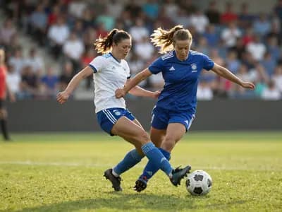 Players contesting the ball during a women's football match