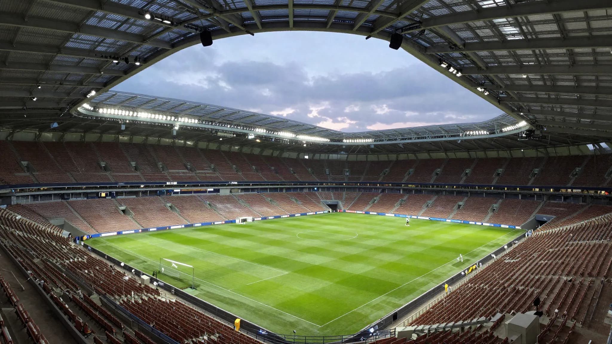An empty modern football stadium at dusk