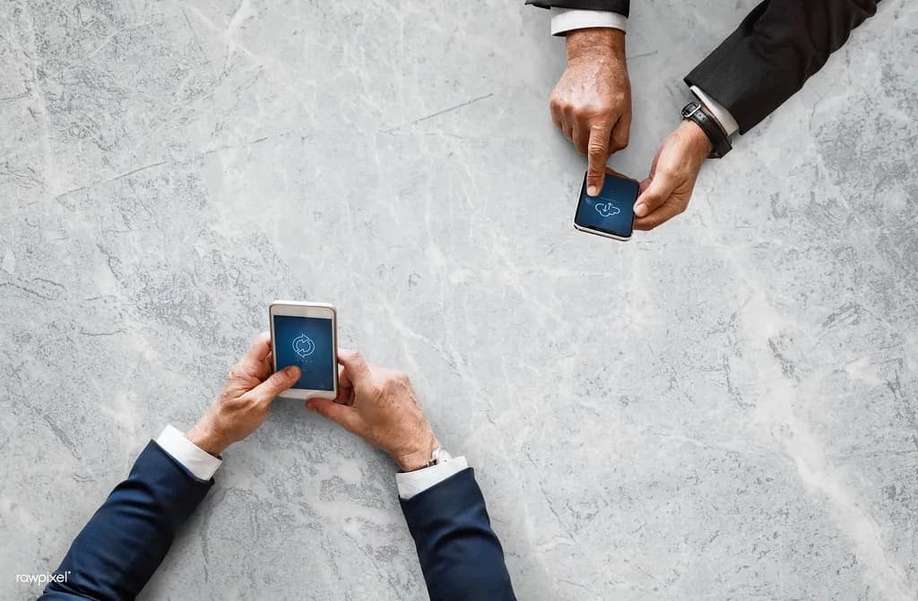 A small group of friends laughing together while sharing photos on a phone